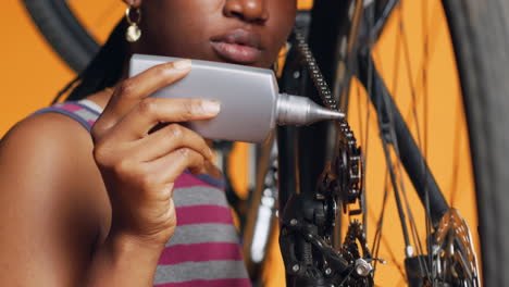 Technician-using-specialized-lubricant-to-repair-squeaky-bicycle-chain