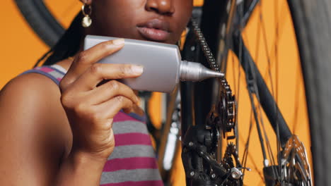 técnico que usa lubricante especializado para reparar la cadena de bicicleta que chirría
