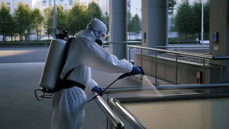 Worker in Hazmat Suit Disinfecting Public Railings