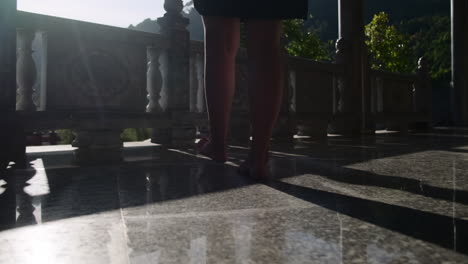 Woman Walking Barefoot on a Temple Balcony
