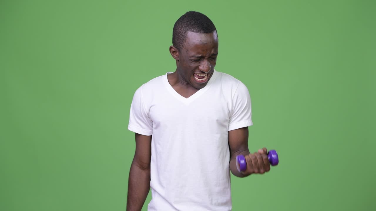 Young African man exercising with dumbbells