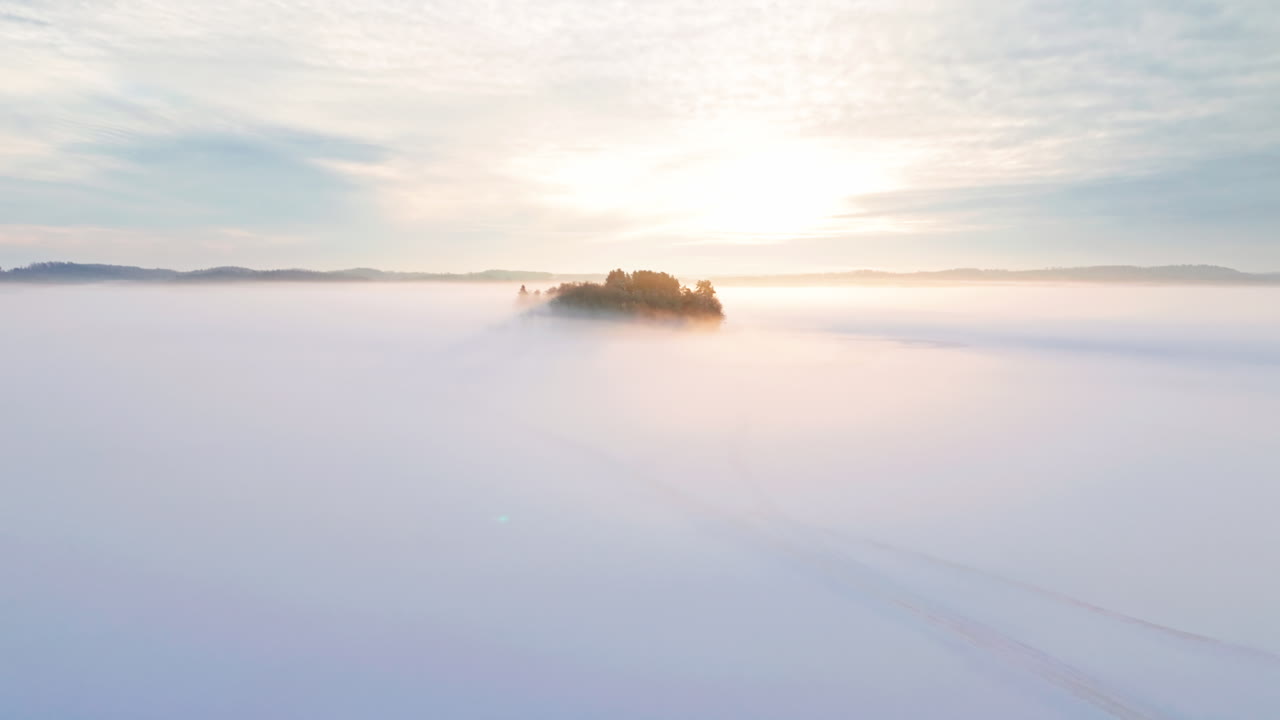 얼어붙은 호수 또는 바다 얼음 중간에 있는 작은 섬 또는 섬, 안개나 안개에 싸여 있다.