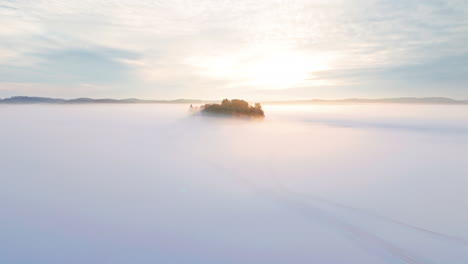 a small island or isle in middle of a frozen lake or sea ice engulfed in fog or mist