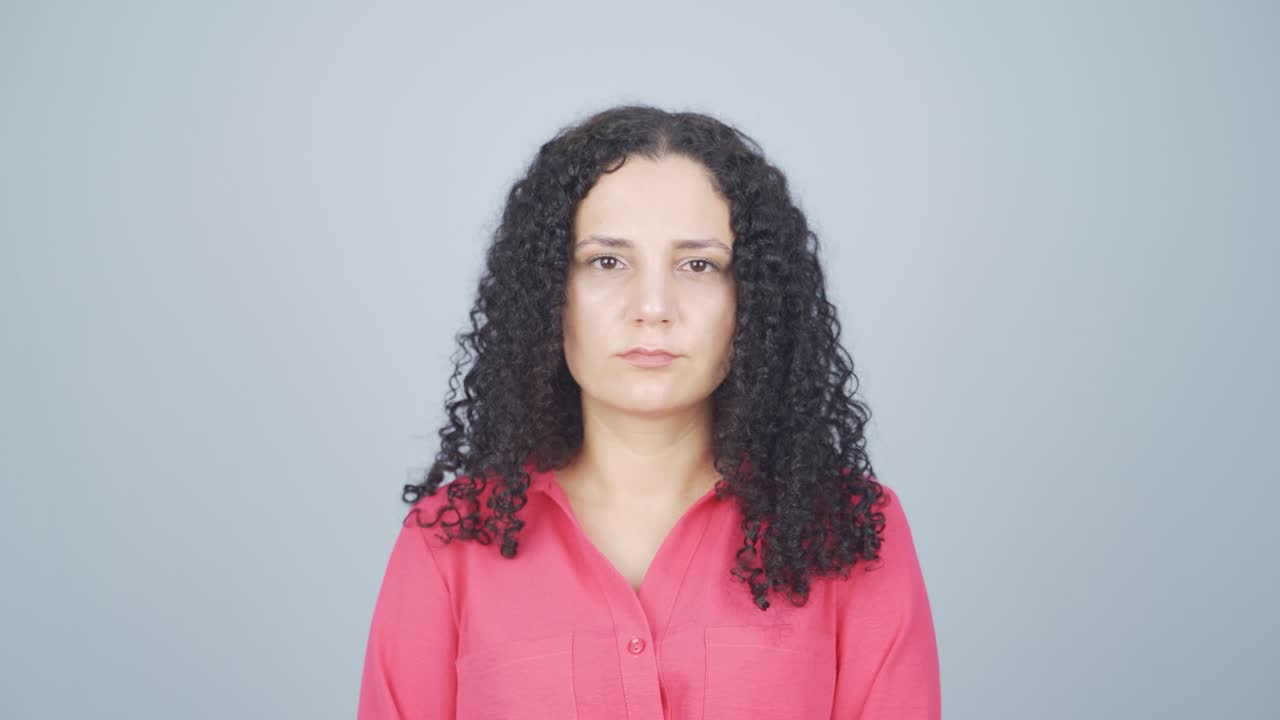 Young woman looking at camera with dull expression.