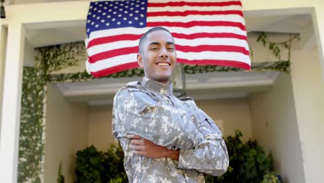 portrait of happy biracial male soldier in garden over american flag