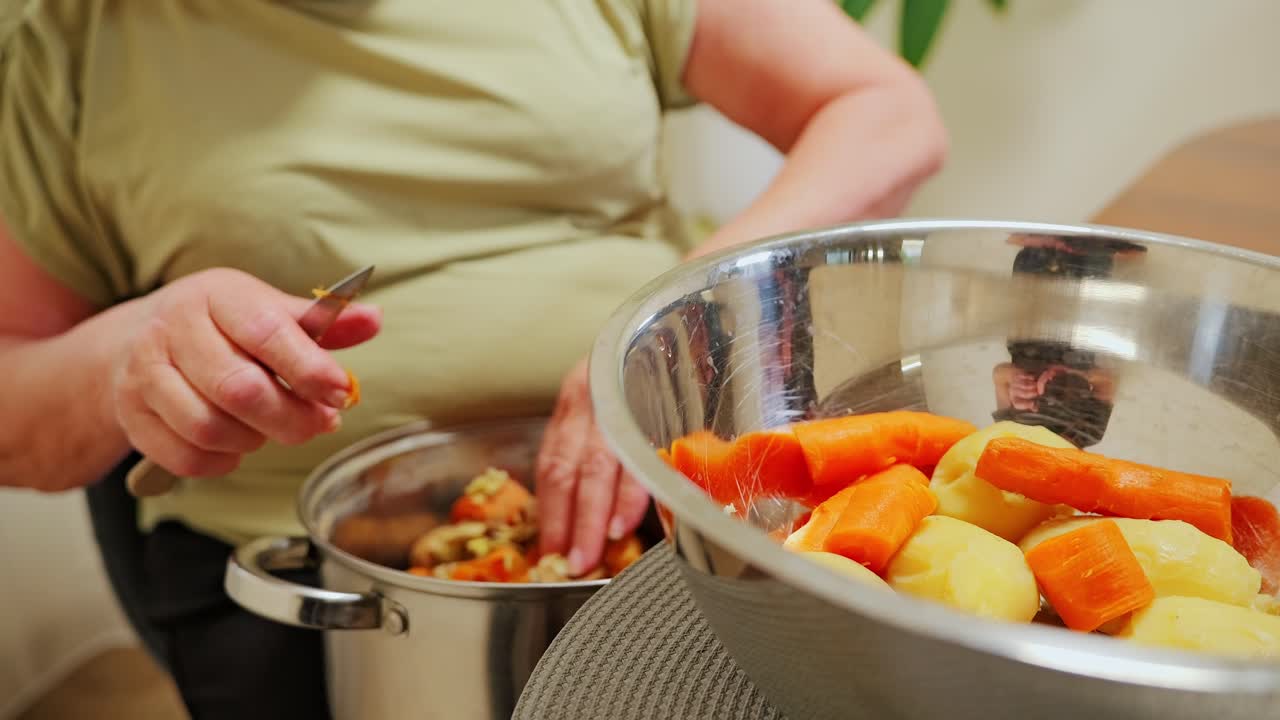 Elder gently peels warm carrots into bowl beside kitchen table in slow motion