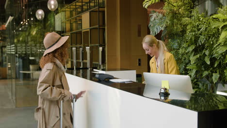 Side-view-of-redheaded-guest-in-the-reception-of-a-hotel