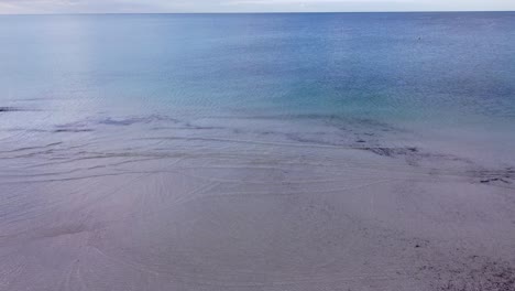 Aguas-Poco-Profundas-Del-Océano-índico-Al-Atardecer,-Playa-Busselton---Vista-Aérea-Inclinada-Hacia-Arriba