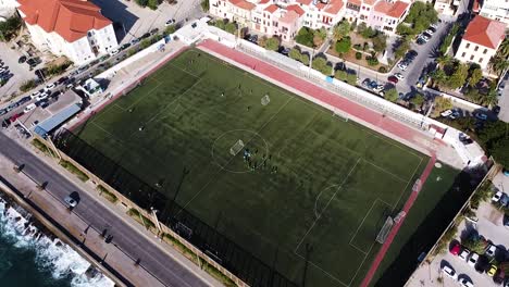 beautiful city of rethymno and green vibrant football field, aerial view