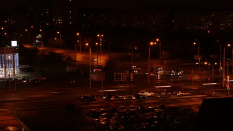 time lapse of cars driving on crossroad in city at night, aerial view