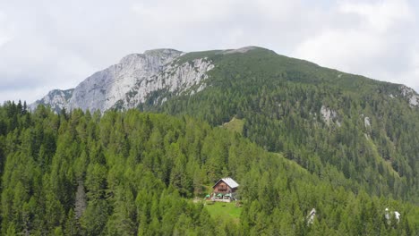 Tiro-De-Drone-Para-Una-Cabaña-Solitaria-En-La-Colina-Rodeada-De-Bosque