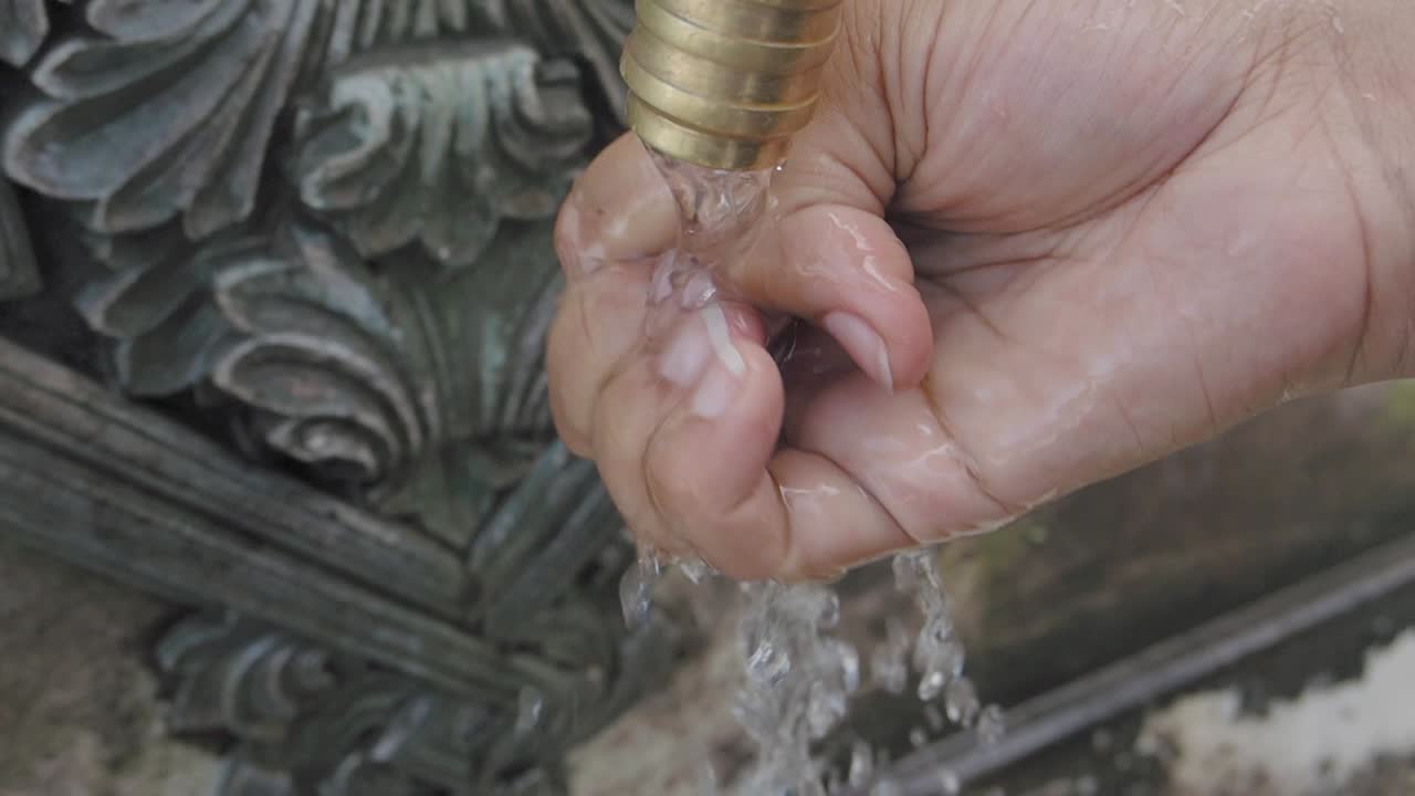 Washing Hands at a Public Fountain