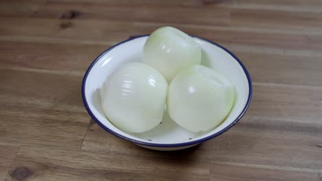 Cebollas-Blancas-En-Un-Plato-Sobre-Una-Mesa-De-Madera-Rústica