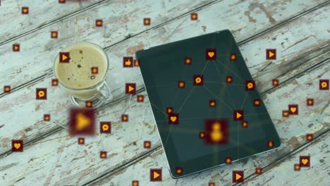 Animation-of-network-of-digital-icons-against-digital-tablet-and-coffee-cup-on-wooden-surface