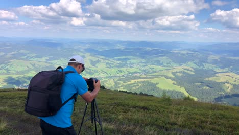 a man photographs a mountain landscape while hiking in the mountains a man photographs a mountain landscape while hiking in the mountains nature photography
