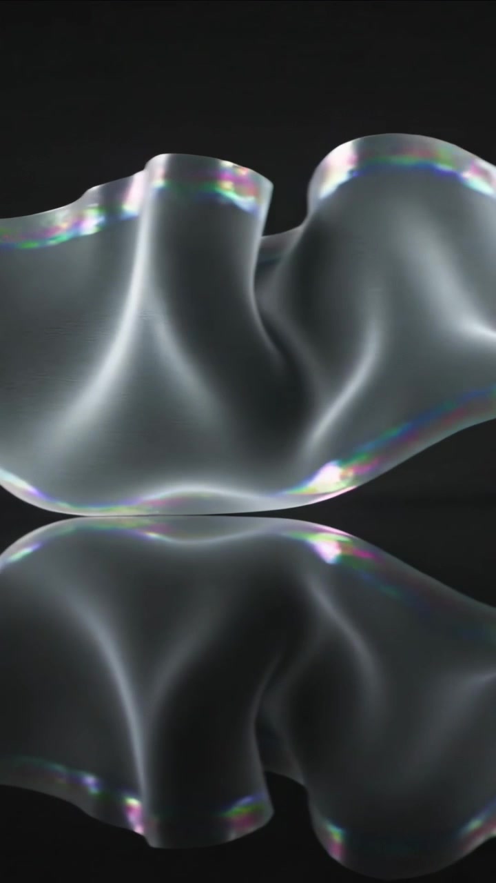 Vertical video: Reacting to point of light, two sheer ribbons twisting on glossy mirror in studio