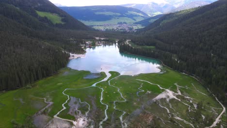 tomada superior del río sinuoso cerca del lago dobbiaco y el bosque en toblacher see, tirol del sur, italia