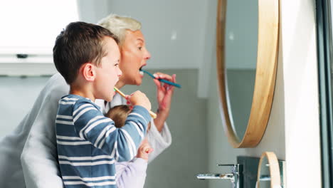 mother, boy child and brushing teeth in mirror