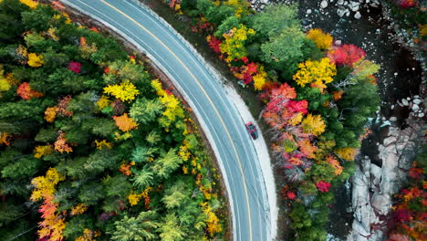 top down drone shot of a van on kancamagus highway new hampshire during fall foliage