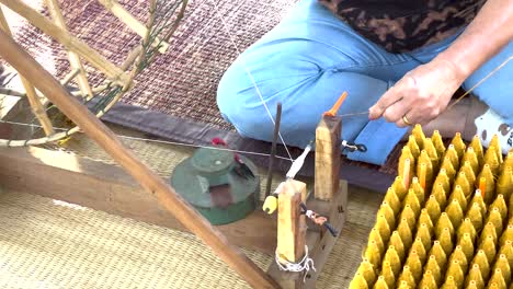 hands crafting silk threads in khao yai