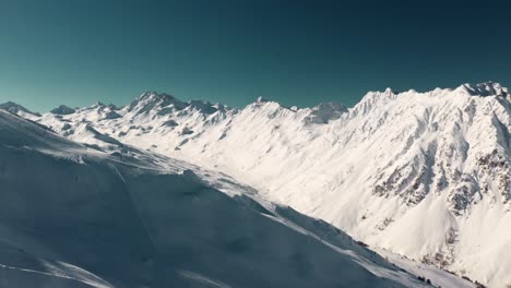 aerial: austrian mountain peaks and snowy backcountry valley