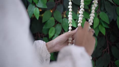 woman's hands arranging a jasmine garland