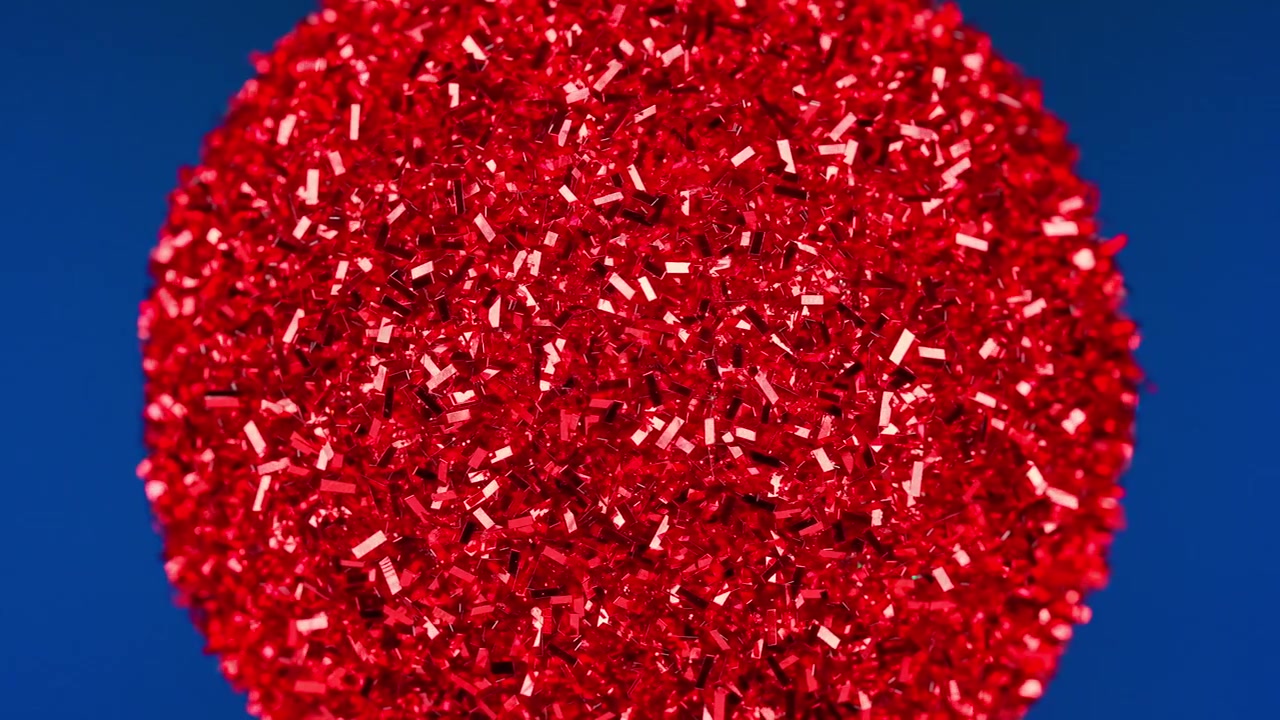 Sparkling Red Glitter Ball Against Blue Background