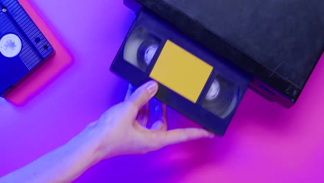 top view of video vhs device and cassette on lilac background