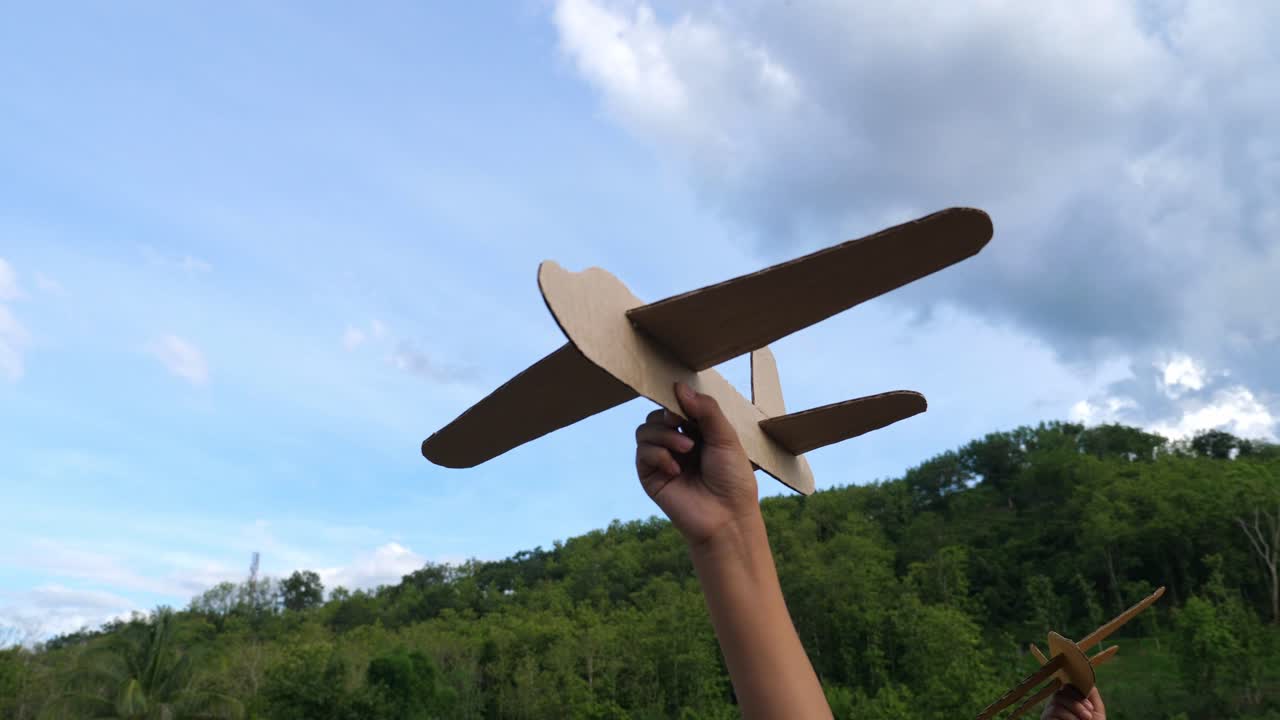 Child Playing with a Cardboard Airplane