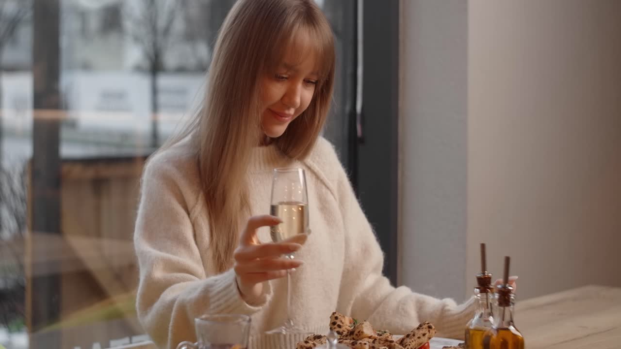 Woman enjoying a meal and champagne at a cafe with a view