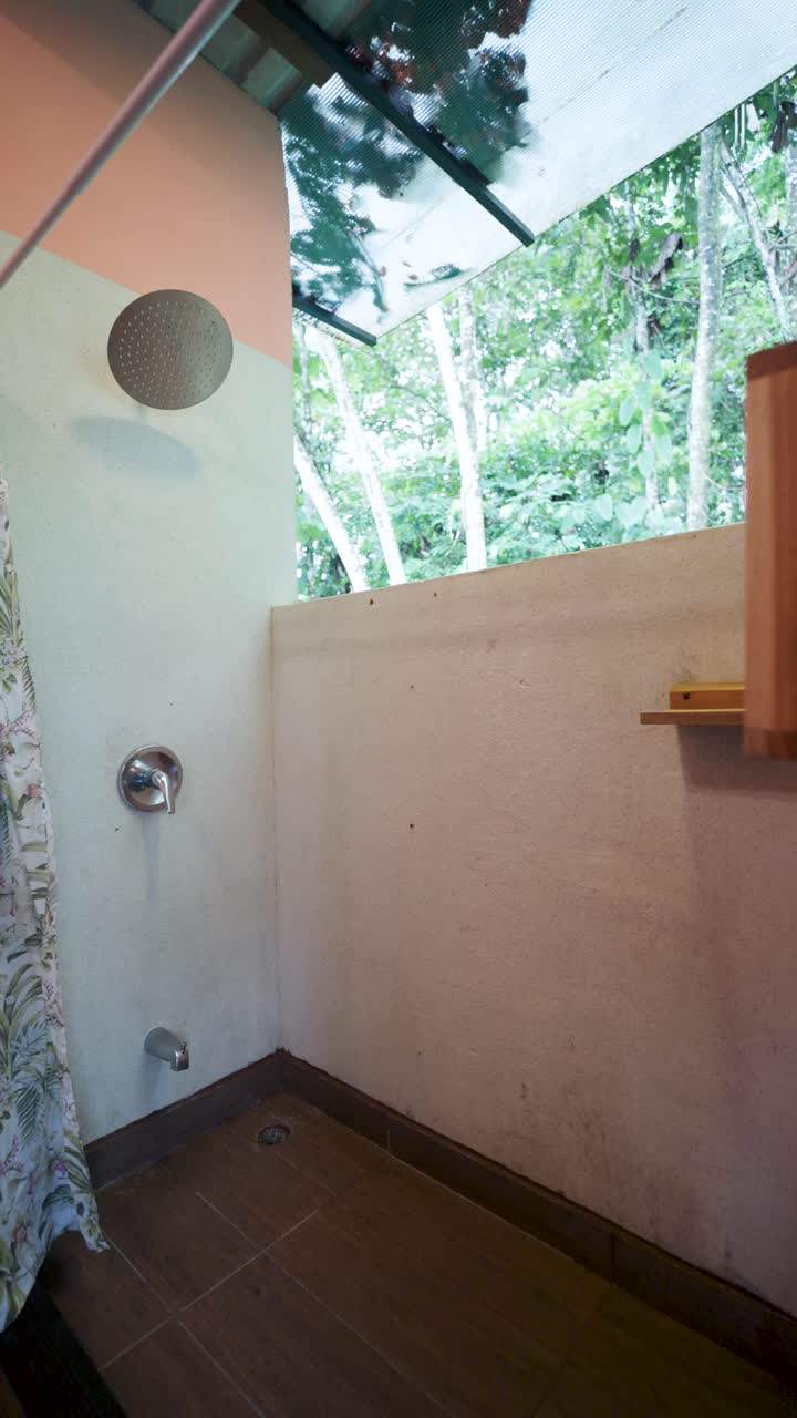 A bathroom with a shower, shower curtain, and window