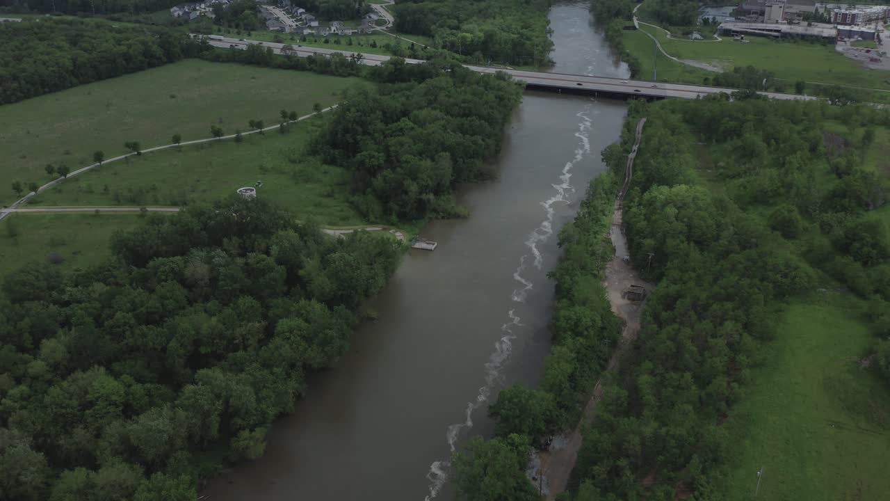 Drone flyver over en flod mod en ensom motorvej i Midtvesten i USA, om sommeren i 4K