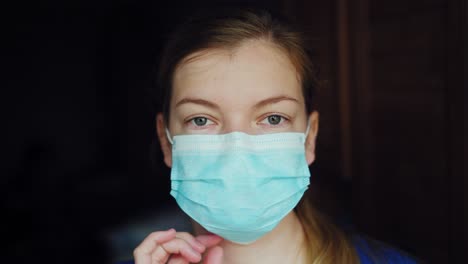 una mujer científica feliz y sonriente quitándose la máscara médica protectora