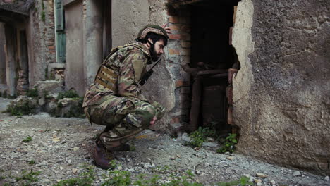 soldier looks through the destroyed door of an old house