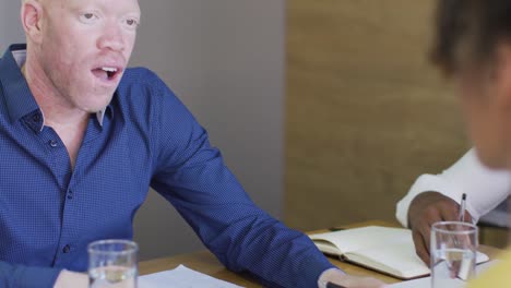 diversas personas de negocios discutiendo con documentos en una reunión en la oficina creativa