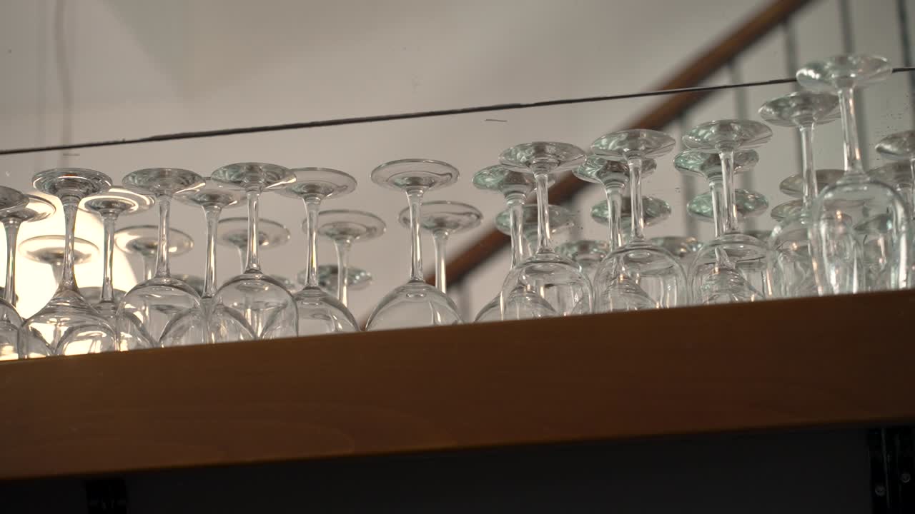 Copas relucientes cuidadosamente dispuestas en un estante de madera en un ambiente acogedor de bistró
