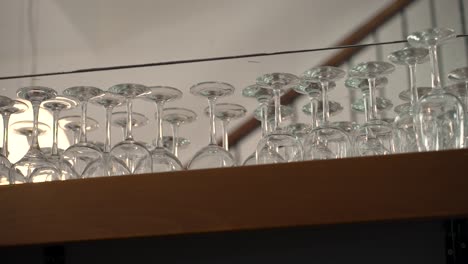 sparkling glasses neatly arranged on a wooden shelf in a cozy bistro atmosphere