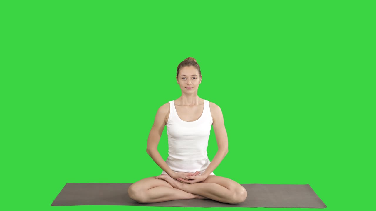 Jovem e bela mulher loira praticando yoga e sorrindo em tela verde, Chroma Key