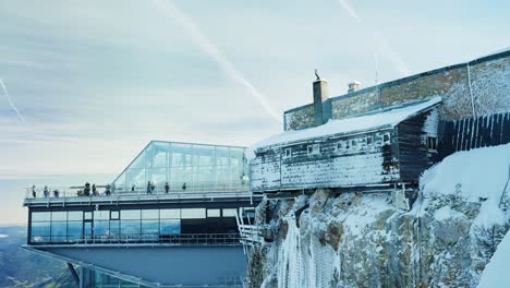 zugspitze summit building through a window on a mountaintop in the alps in winter with snow and rocks