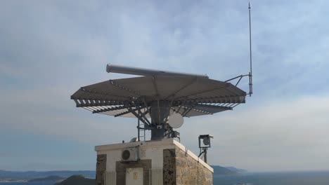 boat traffic control radar in the atlantic sea at the top of the hill with the mountains on the horizon in the background on a sunny summer day, shot blocked from below