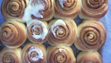 adding cream on cinnamon roll cookies