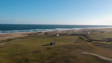 Casas-Ubicadas-En-La-Playa-Costera-De-Rancho-Uruguay,-Olas-De-Agua-Moviéndose-Hacia-La-Tierra-Firme-De-La-Playa-Costera-De-Uruguay