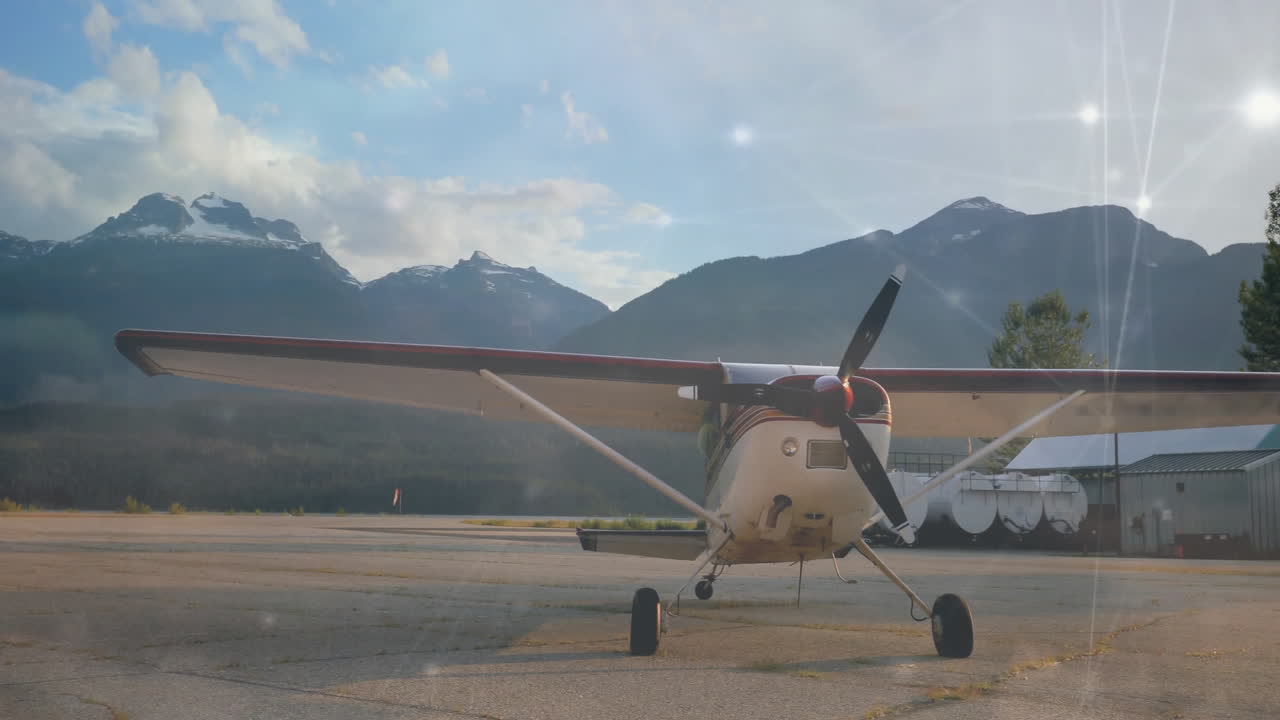 небольшой самолет, припаркованный на взлетно-посадочной полосе с горами на заднем плане, анимация солнечного света