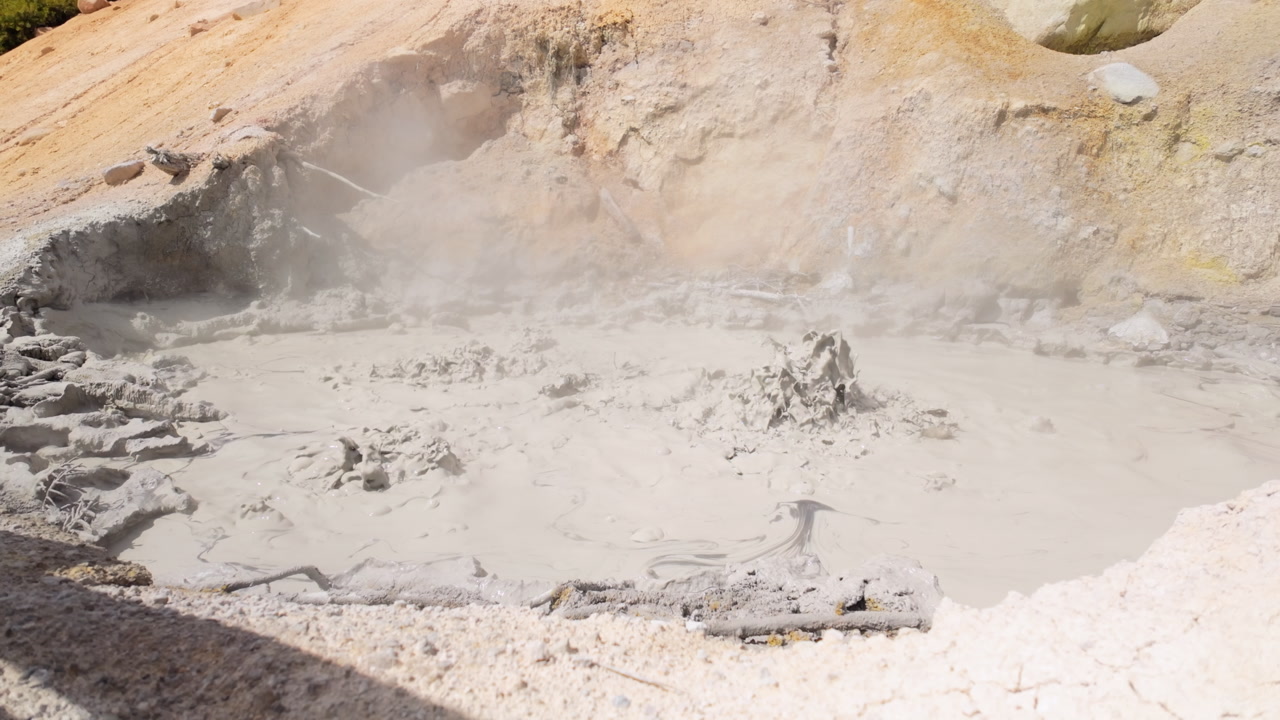 Bubbling geothermal sulfur pool emitting steam on bright day, Lassen Volcanic National Park, California, United States