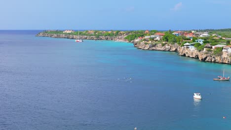 aerial orbit around playa kalki and catamaran in distance, westpunt curacao