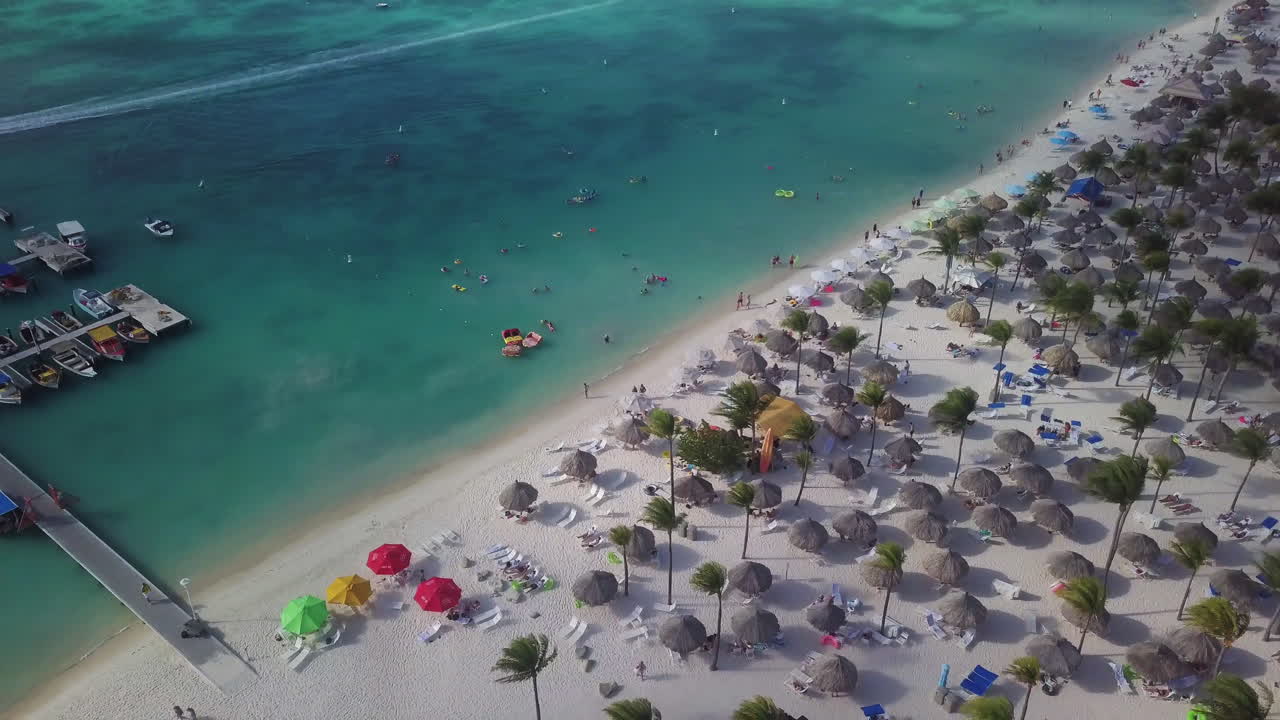 turistas en una playa y nadando en el mar caribe en aruba