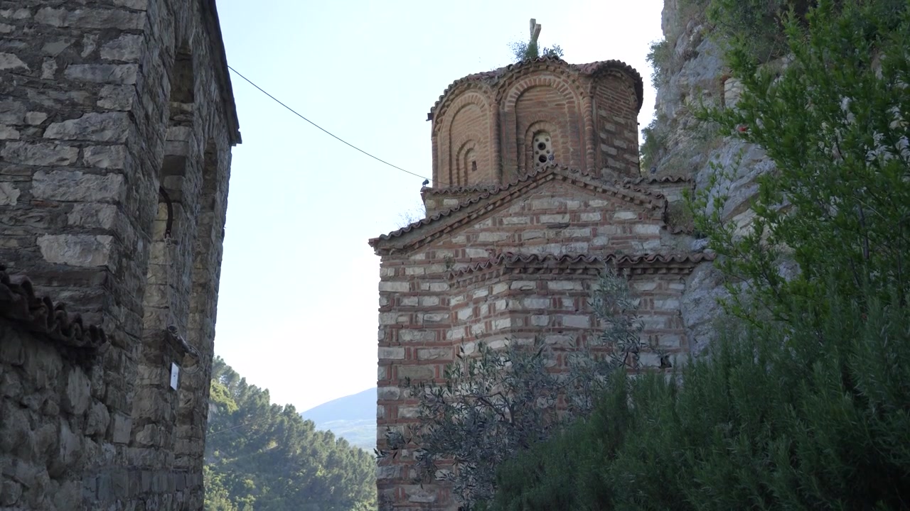 Cupola in mattoni e pietra della Kisha E Shen Mehillit che si erge tra antiche mura a Berat, Albania.