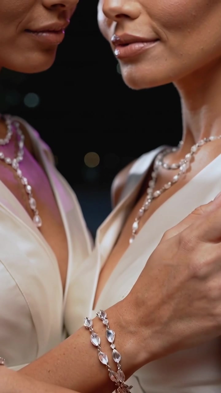 Vídeo vertical: Dedo se aproximando do lábio, duas mulheres contornando o queixo para anúncio de joias com joia, vestidos brancos