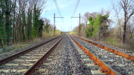caminando en un ferrocarril en el campo en un día soleado, hermoso cielo azul en el horizonte, punto de vista, símbolo de aventura
