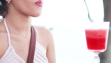 woman sipping watermelon juice with a straw